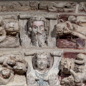 Detail of the heads of Christ and Saint Michael on the keystones of the archivolt of the arch on the right